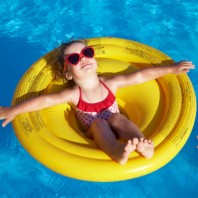 Bimba in piscina su un canottino giallo